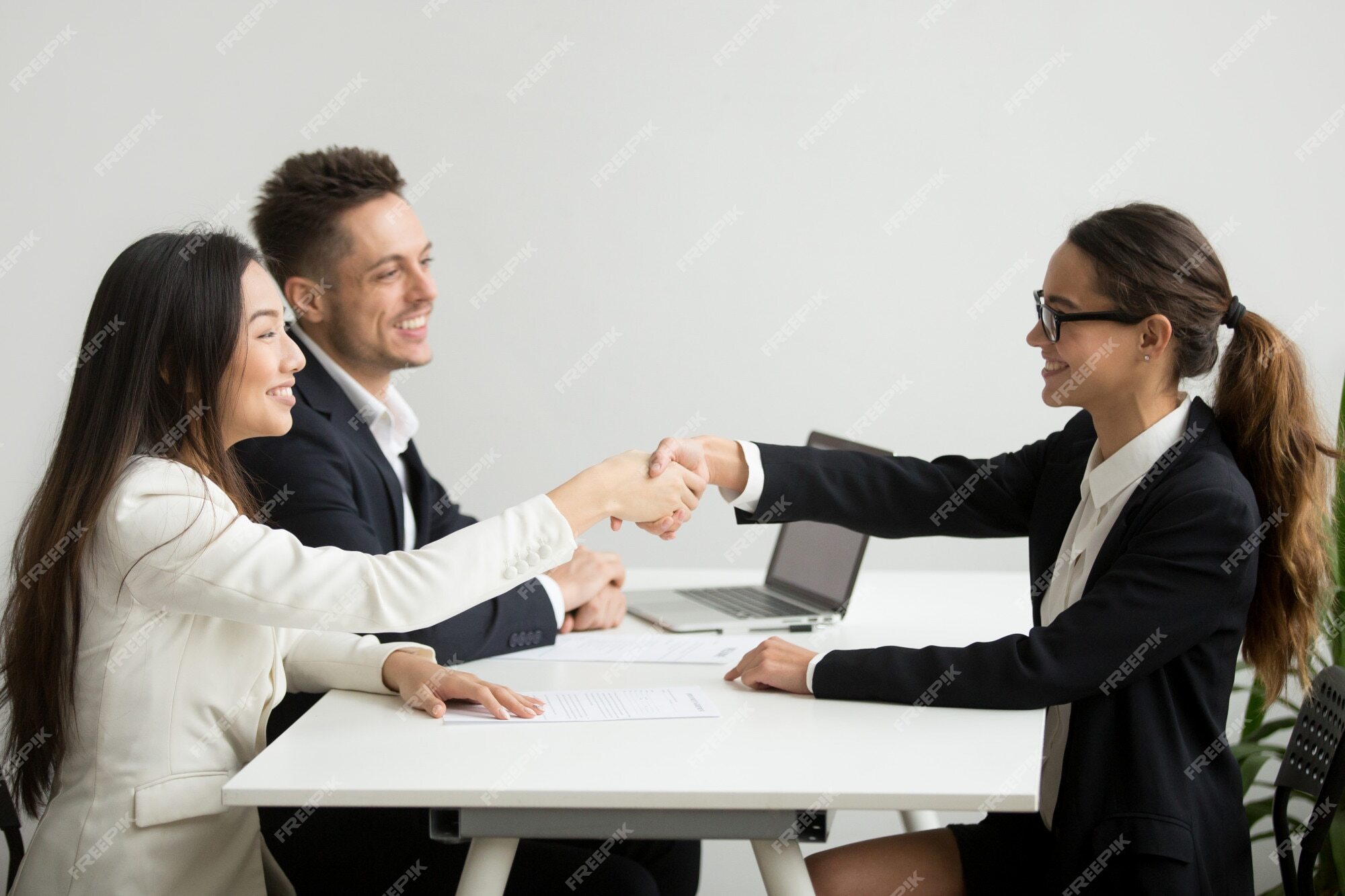 smiling-diverse-businesswomen-shake-hands-group-meeting-deal-concept_1163-4686